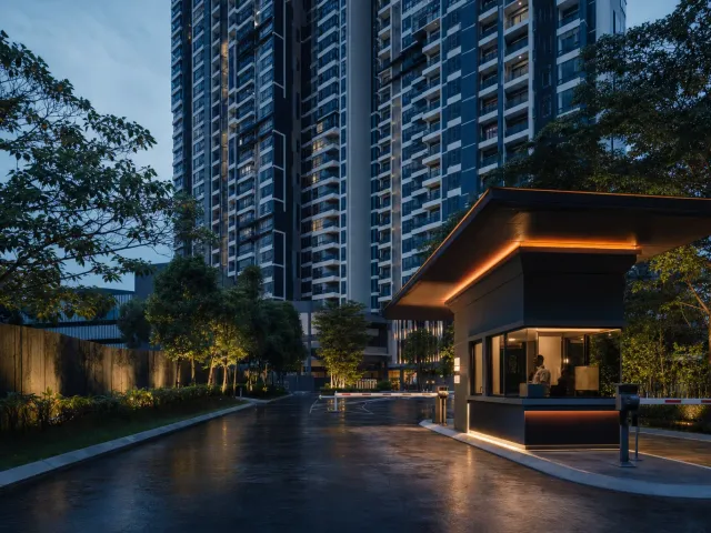 Condominium tower at dusk with a lit guardhouse and vehicle barrier at the entrance